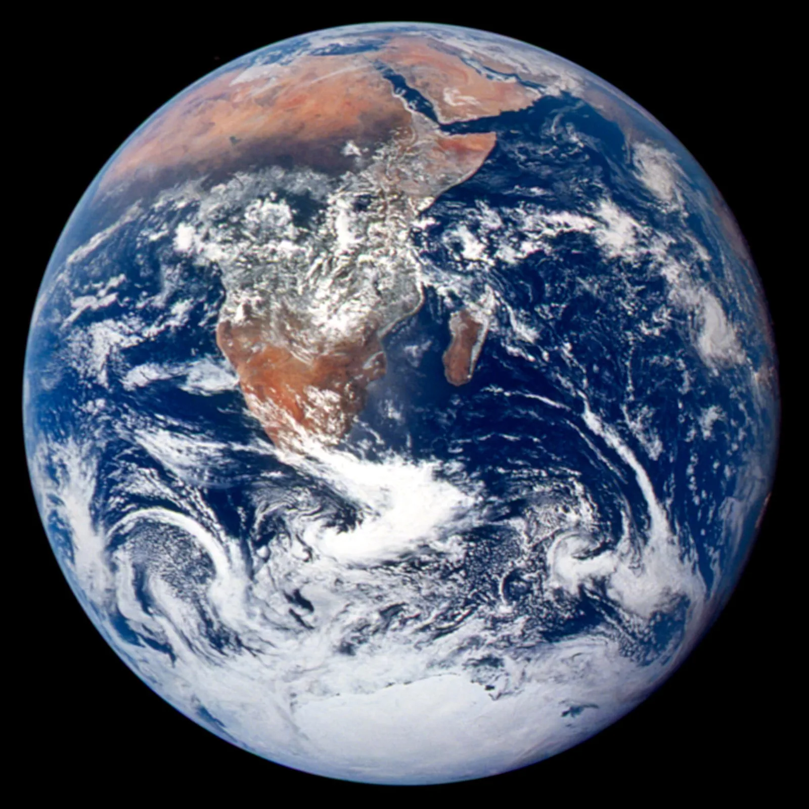 The sunlit globe of Earth against black space, showing Africa, the Arabian Peninsula, and Antarctica beneath white clouds.