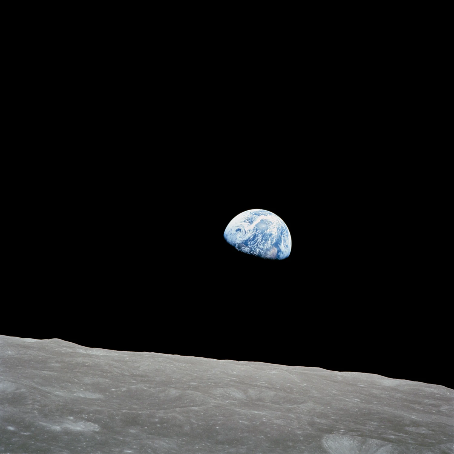 A blue and white Earth above the gray lunar horizon, surrounded by black space.