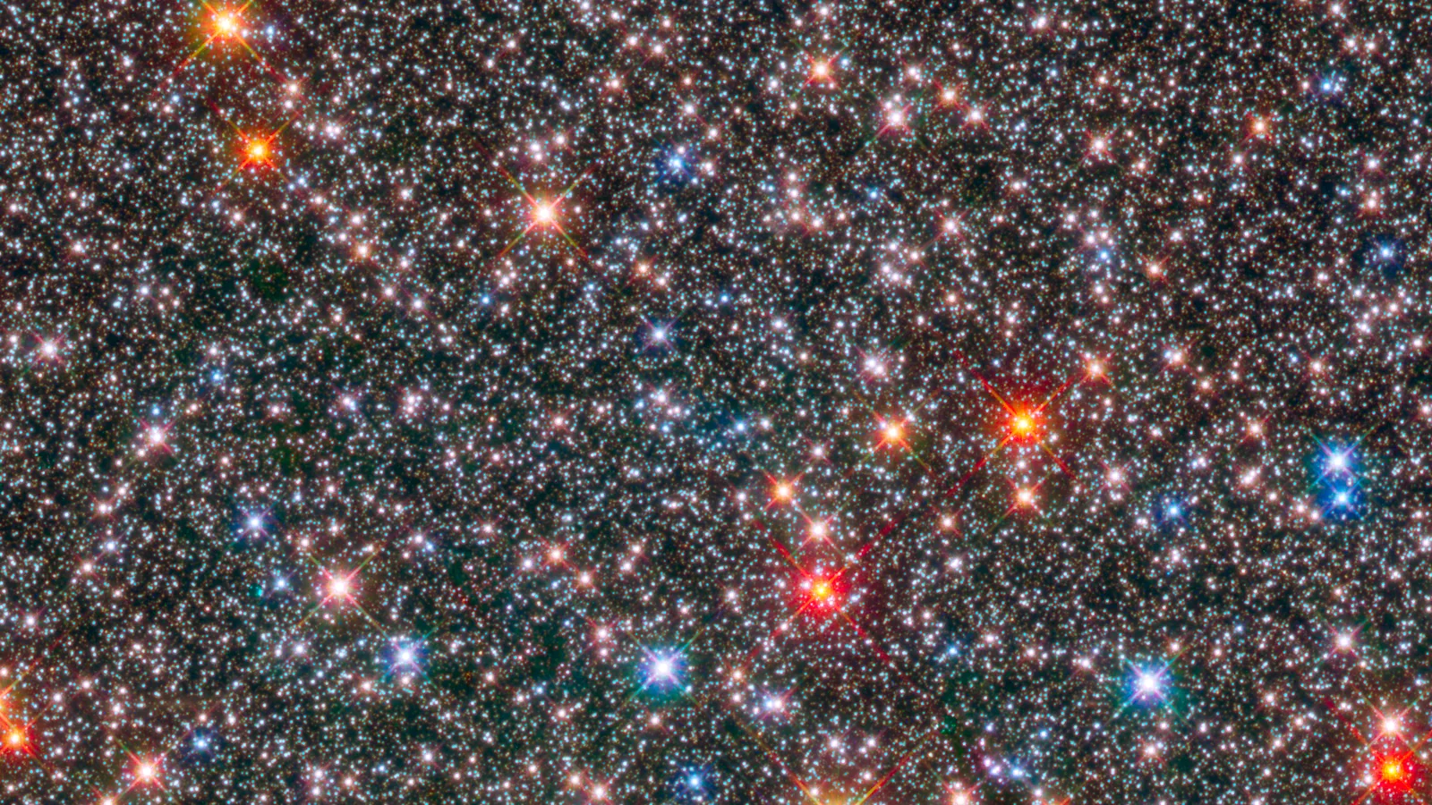 A dense field of white, blue and amber stars in the Milky Way’s central bulge, observed by Hubble in visible and near-infrared light.